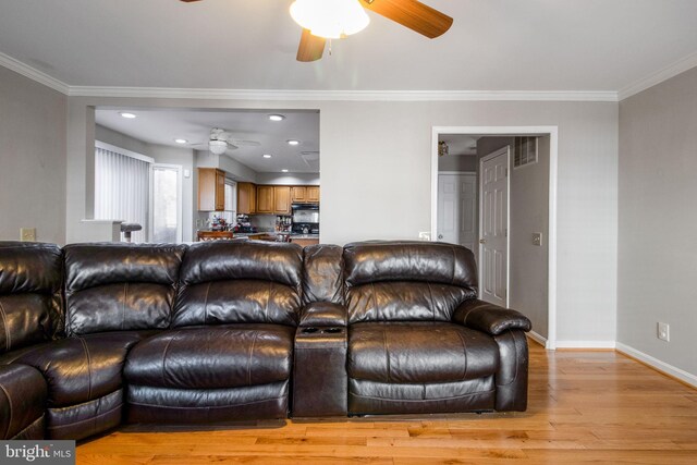 living room featuring ornamental molding, ceiling fan, and light hardwood / wood-style floors