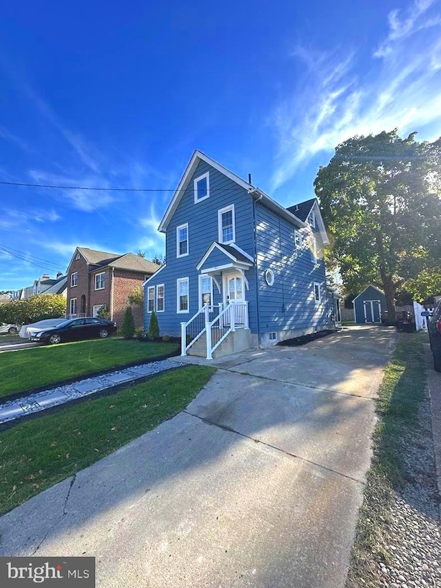 front facade featuring a front yard and a storage shed