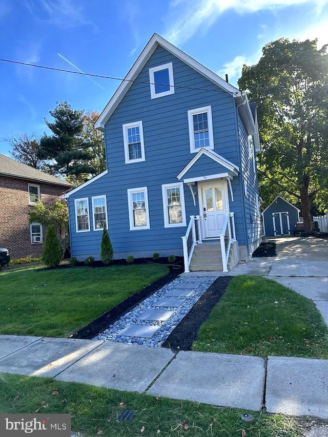 view of front of property featuring a shed and a front yard