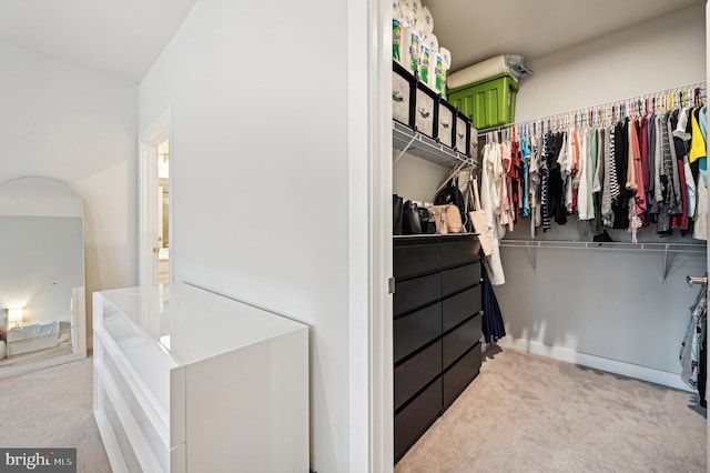 walk in closet featuring light carpet