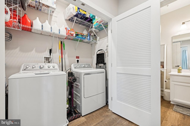 laundry room with light wood-type flooring and washer and clothes dryer