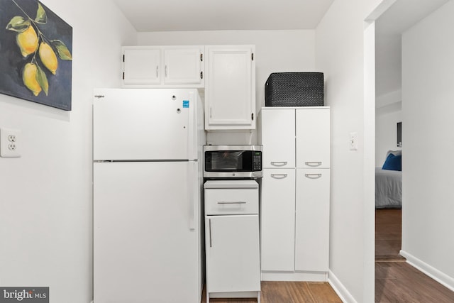 kitchen featuring hardwood / wood-style floors, white cabinetry, and white refrigerator