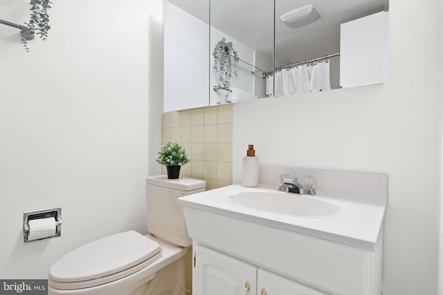 bathroom featuring backsplash, toilet, walk in shower, tile walls, and vanity