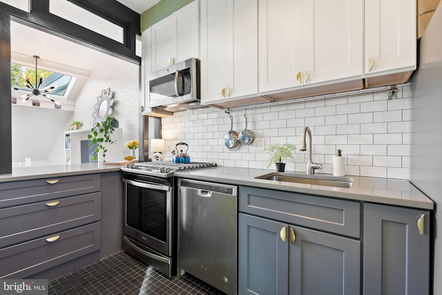 kitchen featuring tasteful backsplash, sink, stainless steel appliances, white cabinets, and gray cabinets