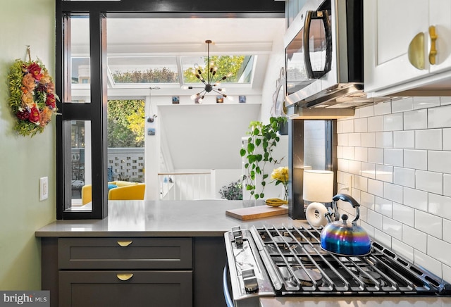 kitchen with stainless steel appliances, tasteful backsplash, and a chandelier