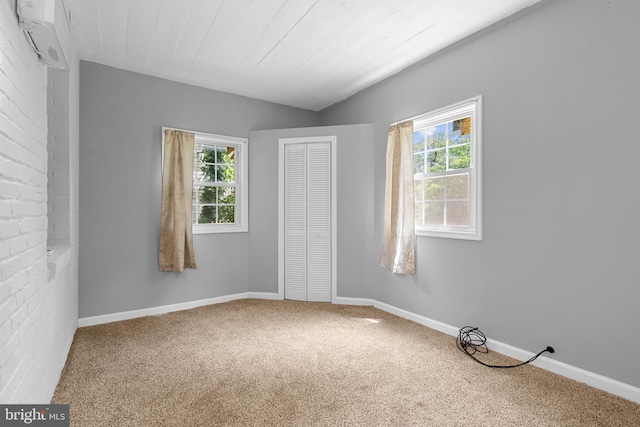 unfurnished room with carpet, a wall mounted AC, and plenty of natural light