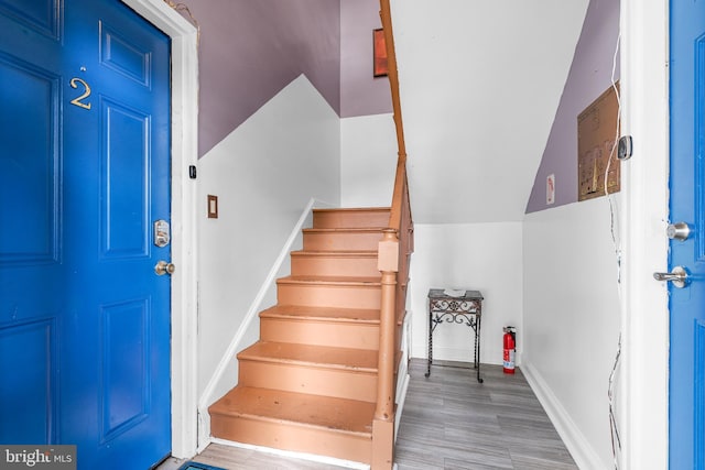 foyer featuring hardwood / wood-style floors and vaulted ceiling