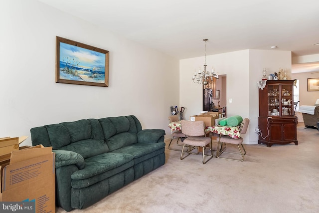 carpeted living room featuring an inviting chandelier