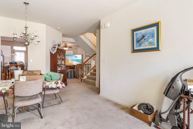 carpeted dining area featuring ceiling fan with notable chandelier