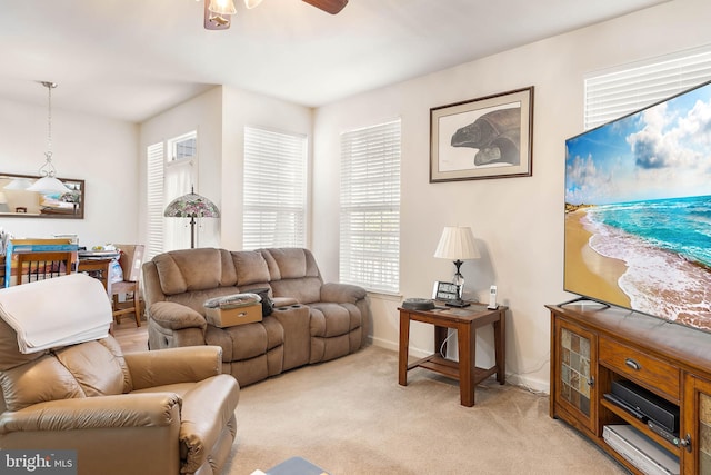 carpeted living room with ceiling fan