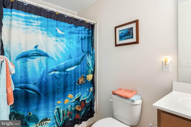 bathroom featuring walk in shower, vanity, and toilet