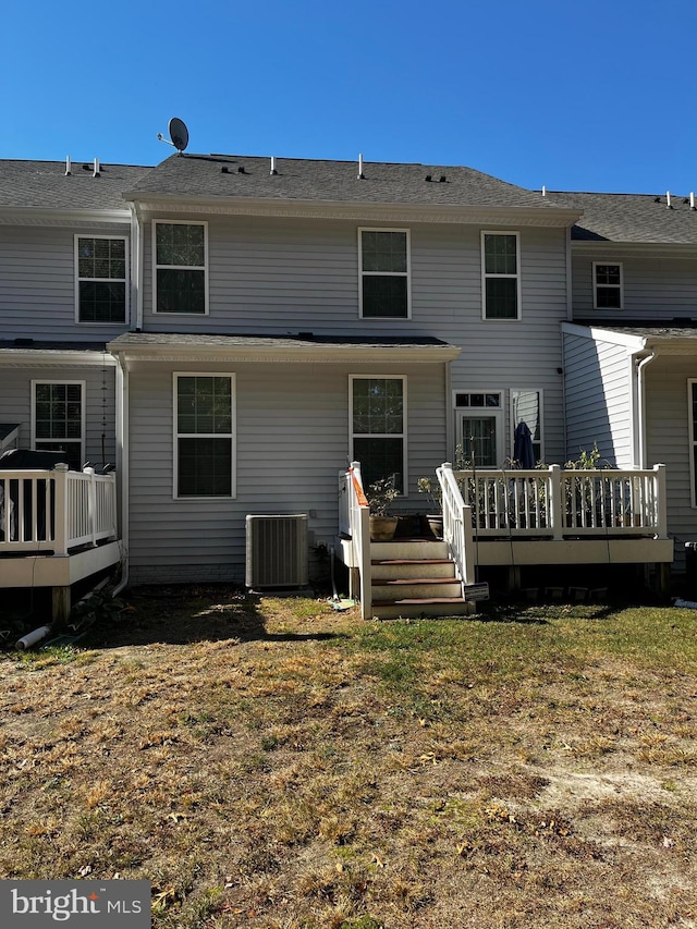 rear view of property featuring a yard, a deck, and cooling unit