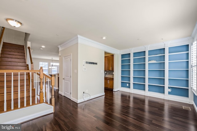 interior space featuring ornamental molding, dark wood-type flooring, and a notable chandelier