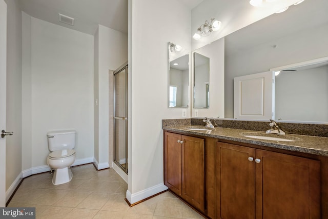 bathroom featuring toilet, walk in shower, vanity, and tile patterned floors