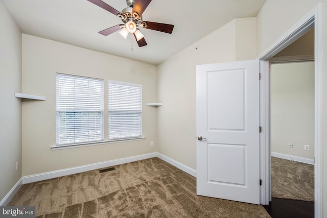 carpeted empty room with ceiling fan and vaulted ceiling