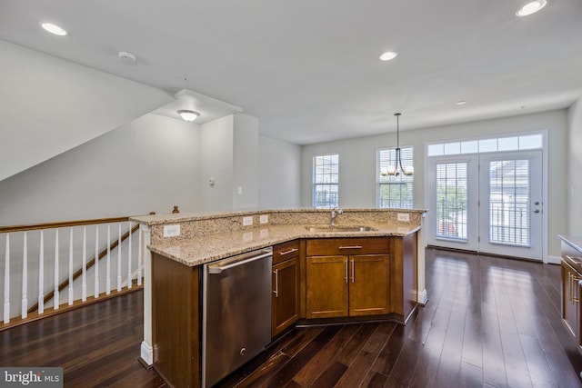 kitchen with sink, dishwasher, hanging light fixtures, dark hardwood / wood-style floors, and a kitchen island with sink