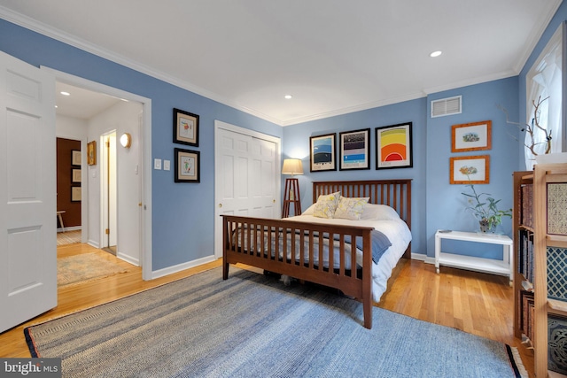 bedroom featuring hardwood / wood-style floors, a closet, and ornamental molding