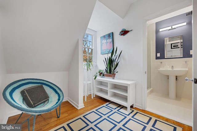 living area with wood-type flooring and vaulted ceiling