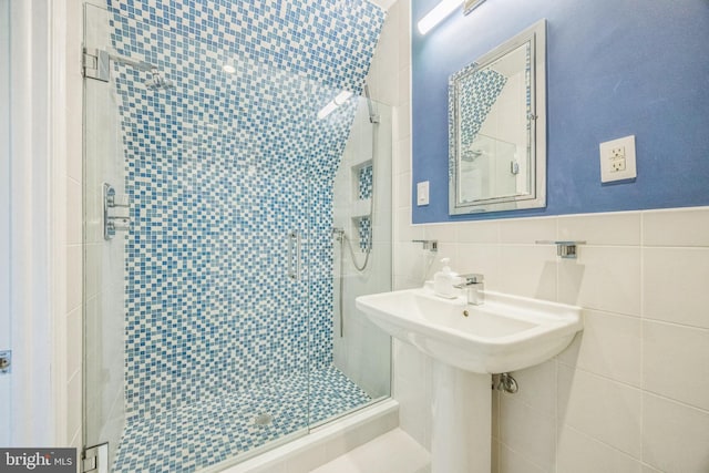 bathroom with walk in shower and tile walls