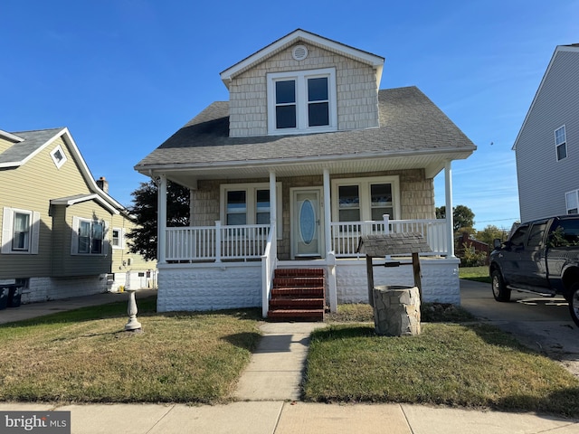 bungalow-style home featuring covered porch and a front lawn