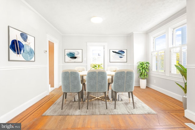 dining area featuring ornamental molding and wood-type flooring