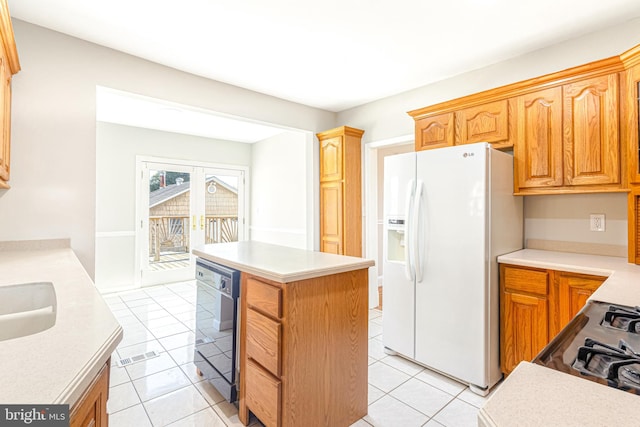 kitchen featuring light tile patterned floors, black dishwasher, white refrigerator with ice dispenser, and a kitchen island