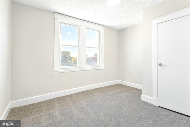 unfurnished bedroom with a textured ceiling and carpet floors