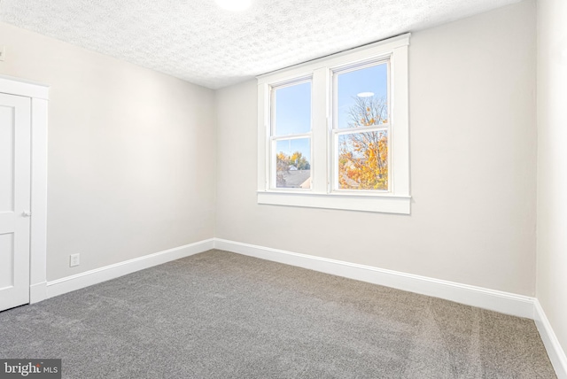 carpeted spare room with a textured ceiling