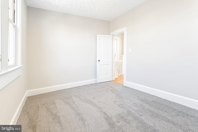 unfurnished room featuring a textured ceiling and carpet floors