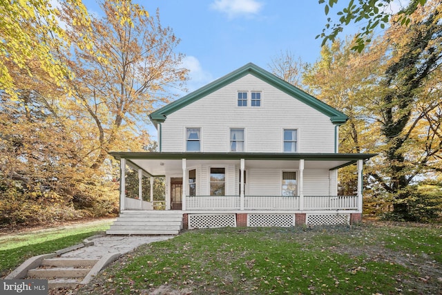 rear view of house featuring a porch and a lawn