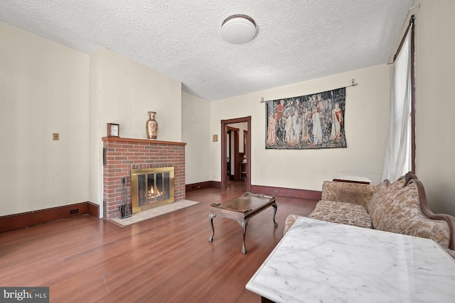 living room featuring a fireplace, hardwood / wood-style floors, and a textured ceiling