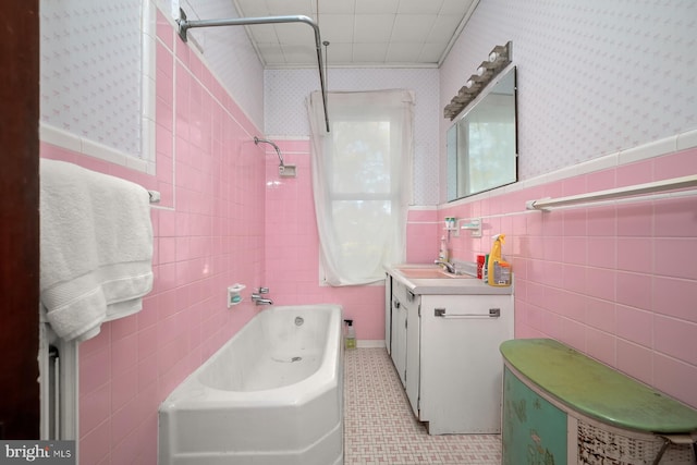 bathroom featuring tile patterned floors, vanity, tile walls, and tiled shower / bath