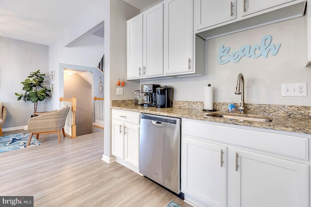 kitchen featuring sink, light wood-type flooring, stainless steel dishwasher, white cabinets, and light stone counters