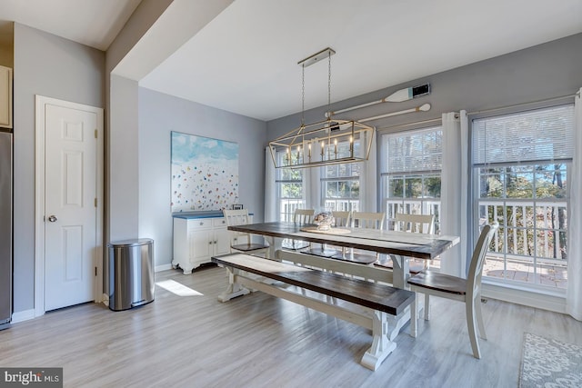 dining room with light hardwood / wood-style floors and a chandelier