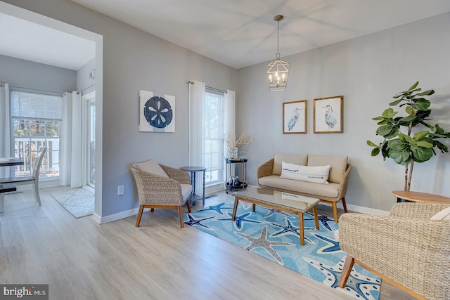 sitting room with light hardwood / wood-style floors and an inviting chandelier