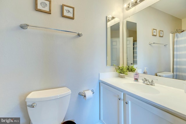 bathroom with toilet, curtained shower, and vanity