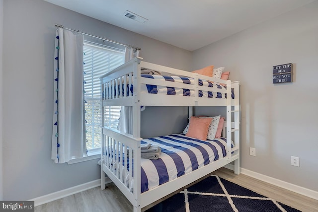 bedroom with hardwood / wood-style flooring and multiple windows