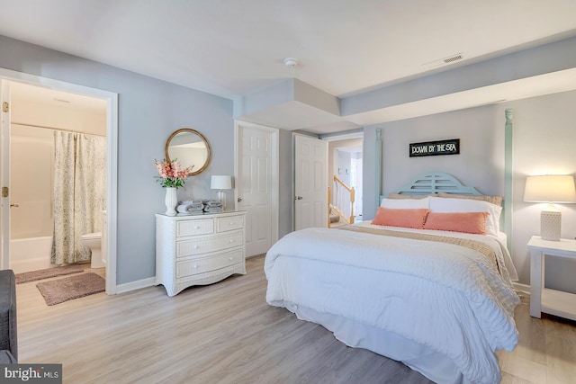 bedroom with light hardwood / wood-style flooring and connected bathroom