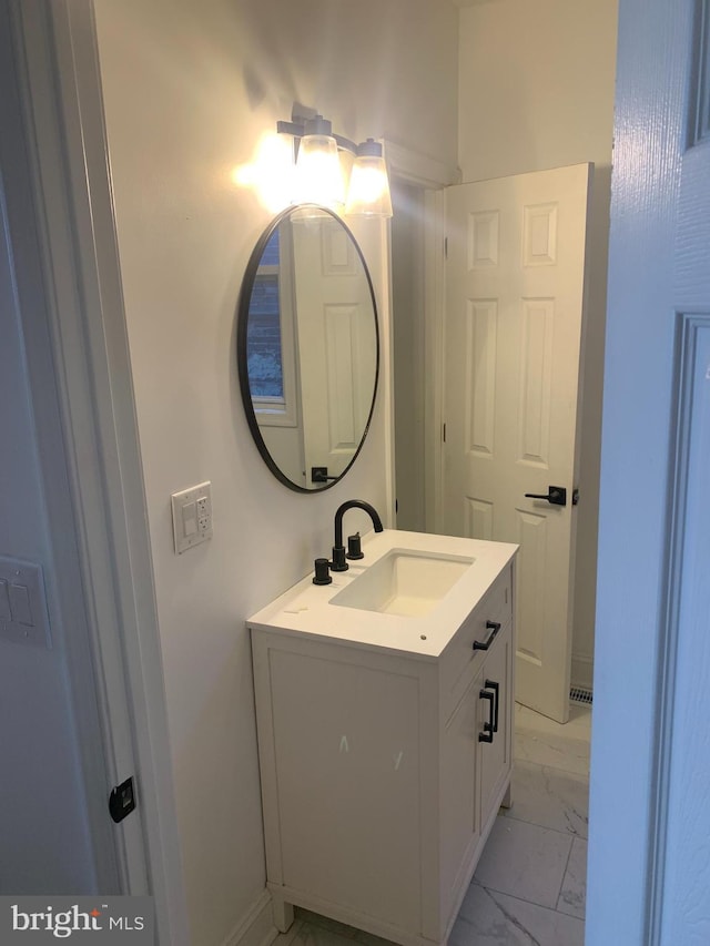 bathroom with marble finish floor and vanity