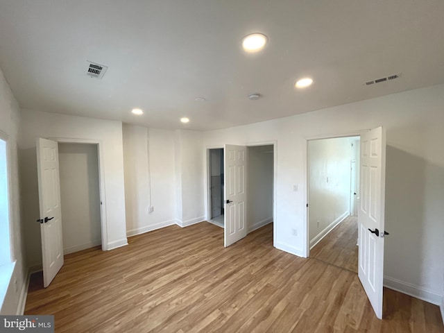 unfurnished bedroom featuring light wood-style floors, recessed lighting, visible vents, and baseboards