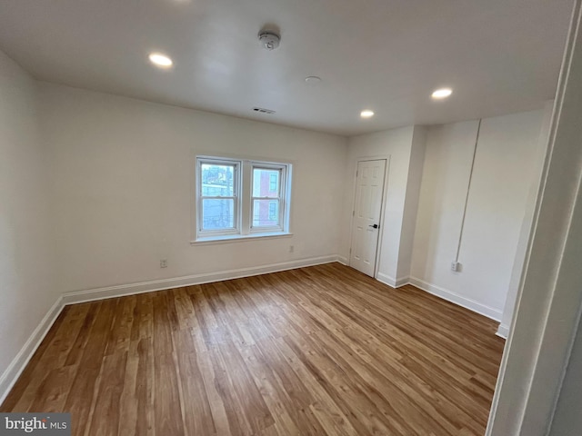 unfurnished room featuring recessed lighting, visible vents, baseboards, and wood finished floors