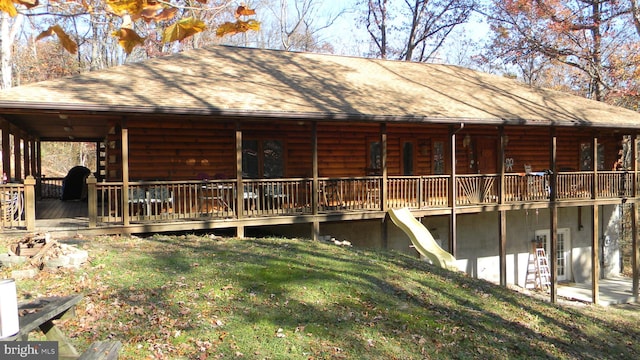 exterior space featuring a front lawn and a wooden deck