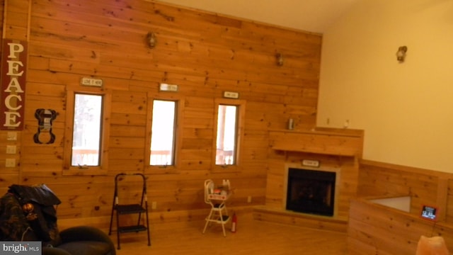 unfurnished living room featuring hardwood / wood-style floors and wooden walls