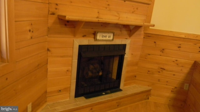 interior details featuring wood walls and a brick fireplace