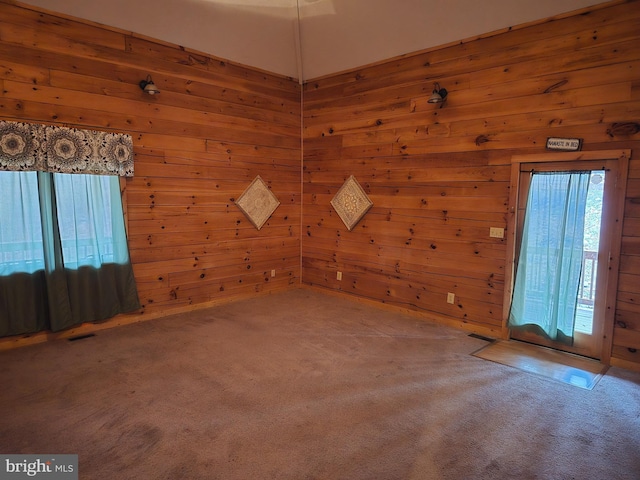 bonus room featuring wood walls, visible vents, and carpet