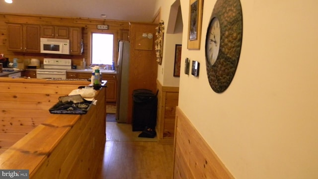 kitchen featuring white appliances and light hardwood / wood-style flooring