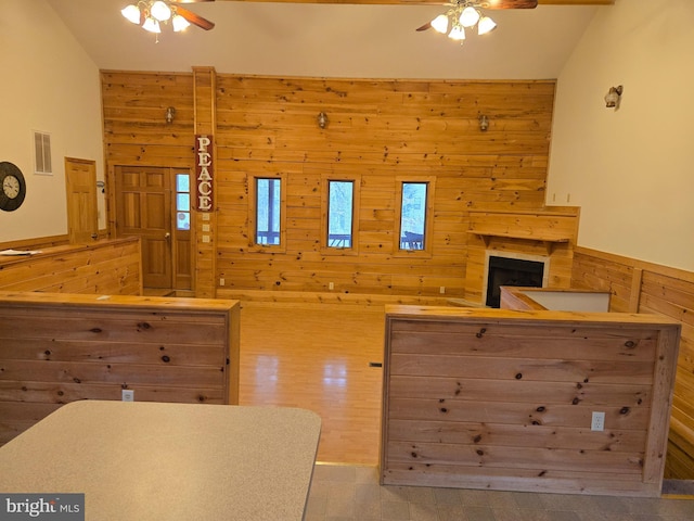 interior space featuring wooden walls, visible vents, and ceiling fan