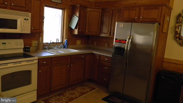 kitchen featuring dark tile patterned flooring, backsplash, white appliances, and sink