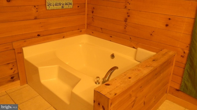 bathroom featuring wood walls, a tub, and tile patterned flooring