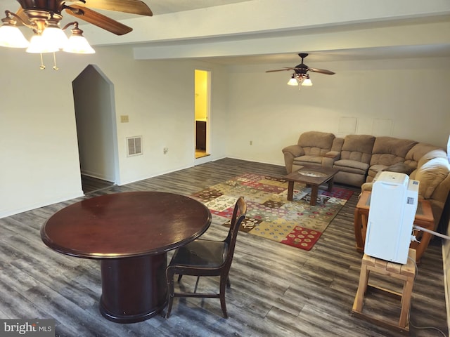 living area featuring a ceiling fan, beamed ceiling, visible vents, and wood finished floors